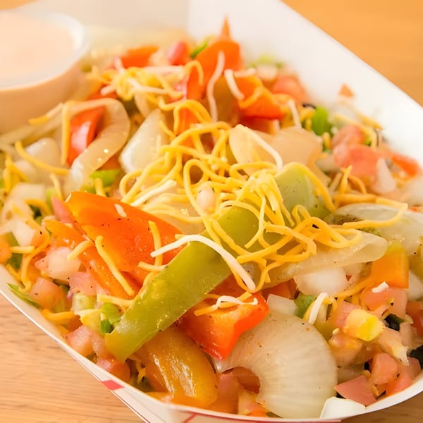 Don Juan Mex Grill's colorful fajita bowl with peppers, onions, cheese, and a side of sauce.