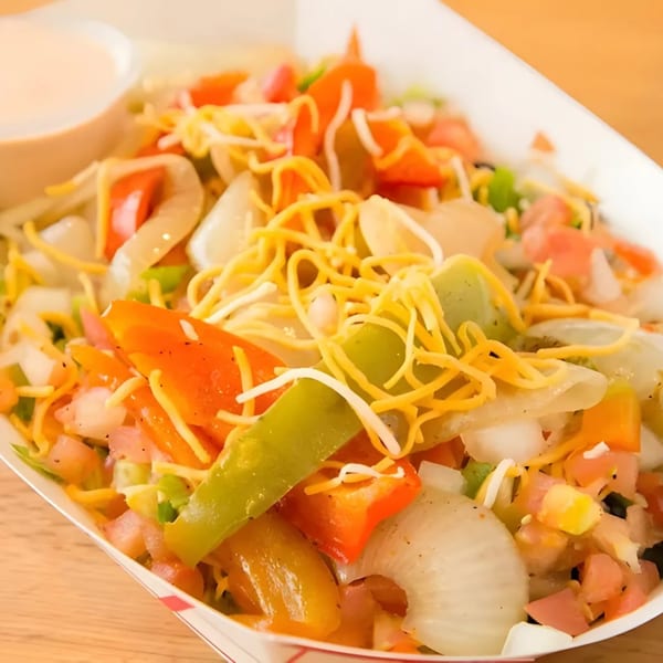 Don Juan Mex Grill's colorful fajita bowl with peppers, onions, cheese, and a side of sauce.
