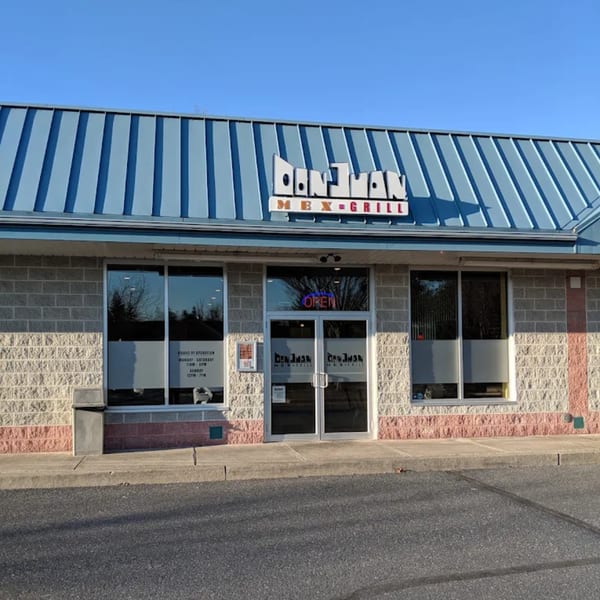 Exterior of Don Juan Mex Grill with a blue roof, brick facade, and "OPEN" sign in the window.